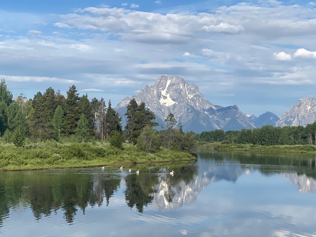 Mountain landscape reflected in a calm lake at Grand Teton National Park.