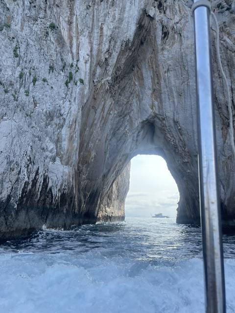 Archway through a rock formation over the sea.