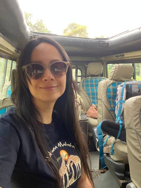 Person inside a vehicle wearing sunglasses with a safari interior.