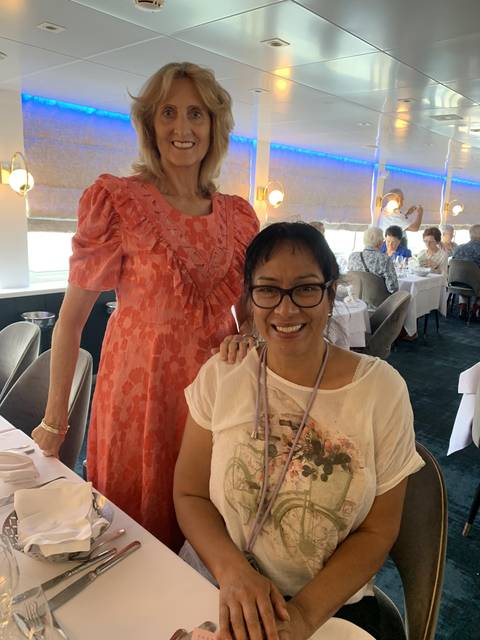 Two women smiling inside a restaurant.