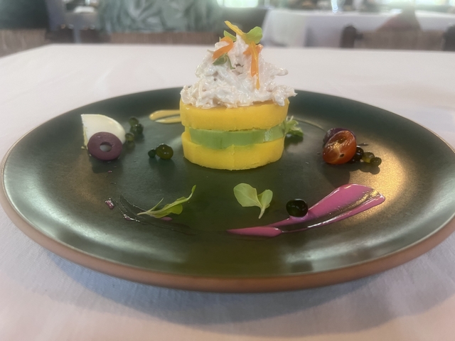 Artfully plated dish with layers of potato and avocado.