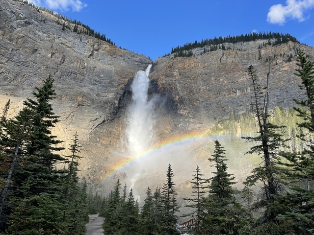 A waterfall cascading down a cliff with a rainbow.