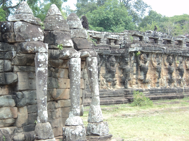 Ruins of ancient stone structures with decorative elephant carvings.