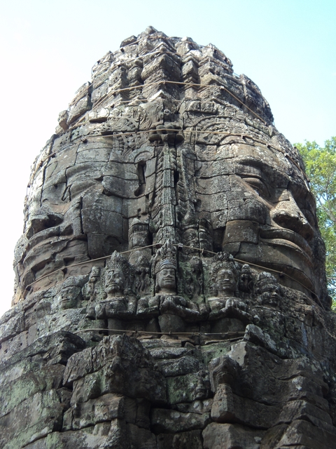 Intricate stone carvings of faces on a temple ruin.