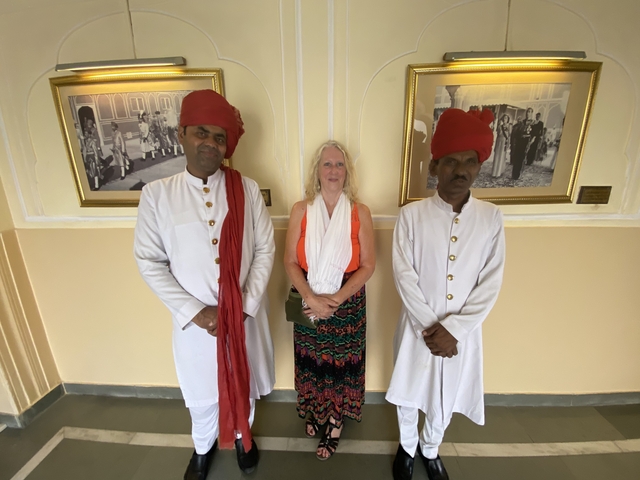 Tourist posing with two traditionally dressed guards.