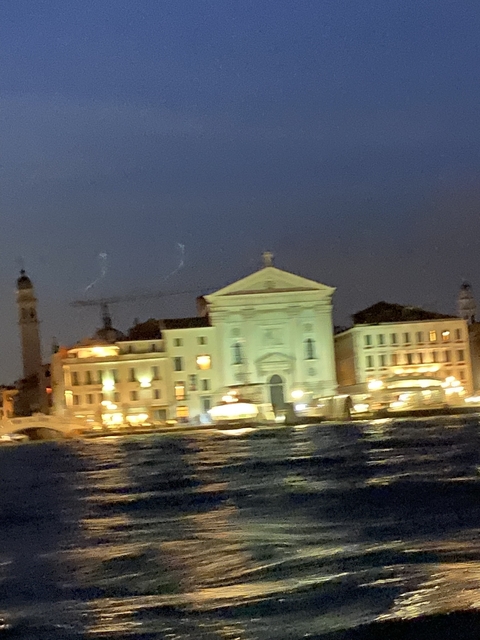 Blurred view of buildings at night with lights.