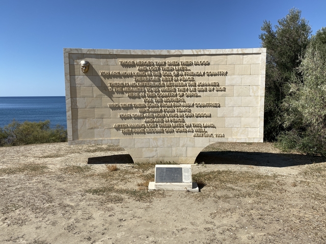 Monument with a commemorative inscription overlooking the sea.