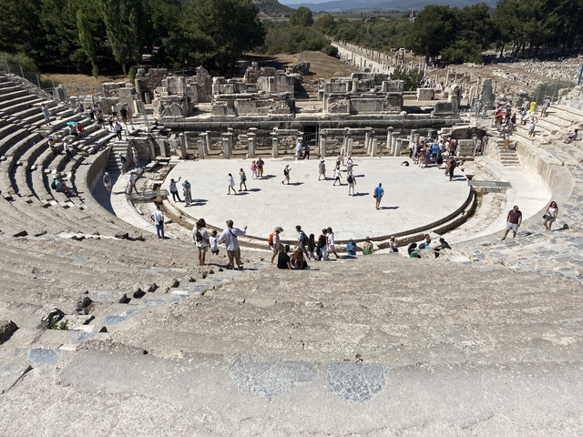 Ancient amphitheater with visitors exploring.