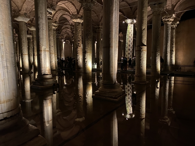 Ancient underground cistern with columns reflected in water.