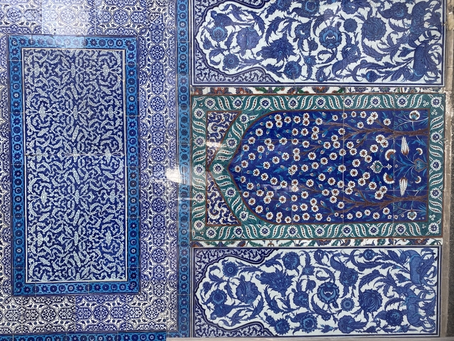 Intricate blue and green tiled wall decoration.