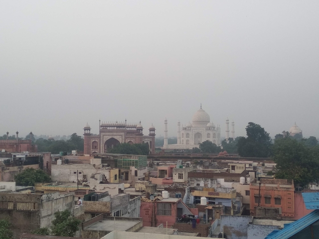 Distant view of the Taj Mahal with surrounding cityscape.