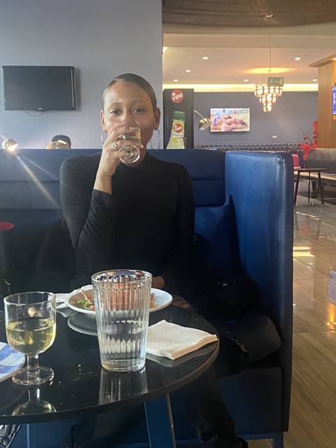Person enjoying a drink at a restaurant.