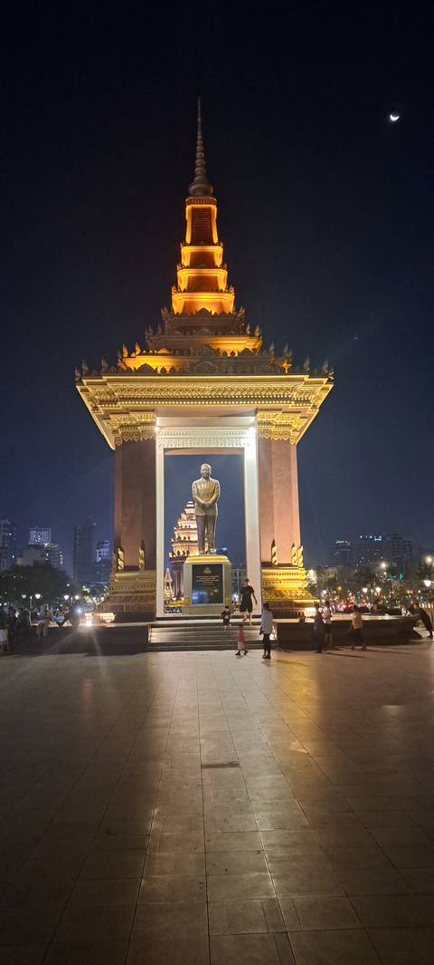 Illuminated monument and statue at night.