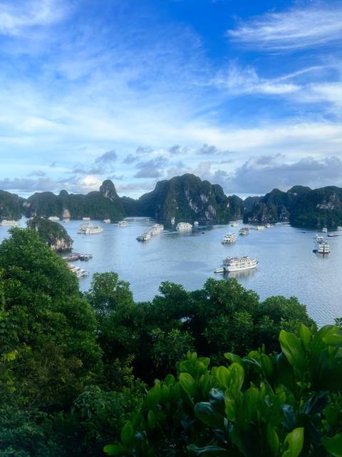 Scenic view of boats in Halong Bay with lush islands.