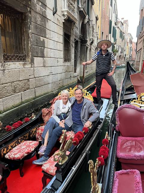 People on a gondola ride in a canal.