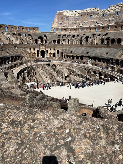 Interior view of the Colosseum with visitors.
