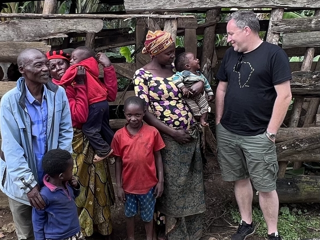A group of people including a family and a tourist smiling together.