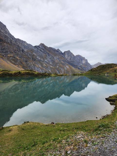 Mountain reflected in a lake with overcast sky.