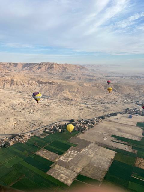 Hot air balloons over a desert landscape.