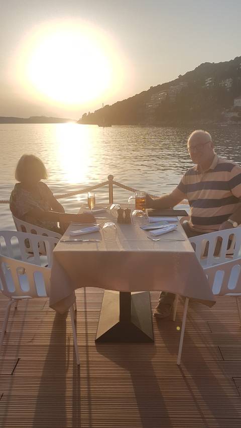 Couple dining outdoors with a scenic sunset.