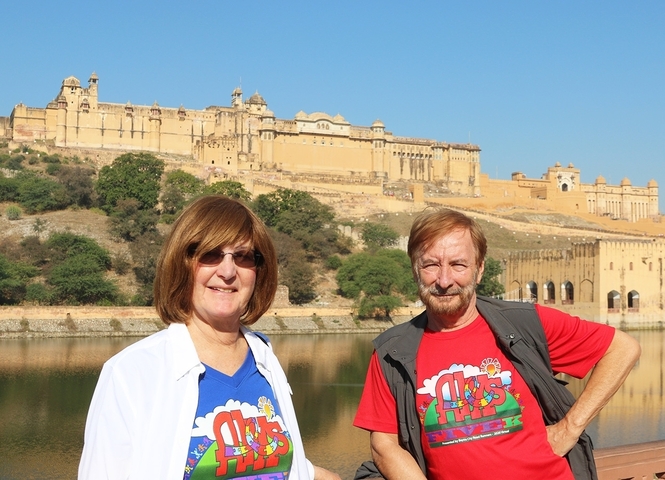 Two people standing in front of an ancient fortress.
