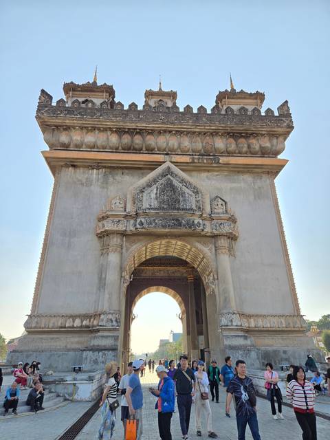 Ornate Asian architecture with people gathered at the entrance.