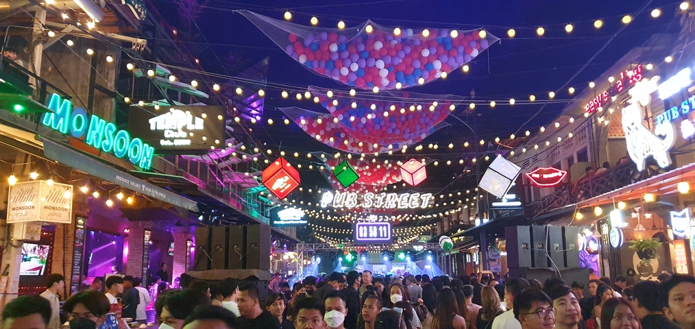 Crowded street with colorful lights and signs.