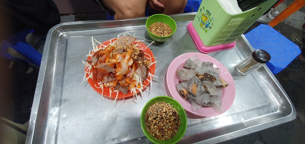 Street food dishes on a metal tray with condiments.