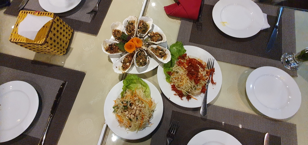 Prepared dishes set on a dining table with plates.