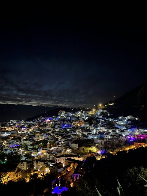 Aerial view of a city illuminated at night, with lights creating a vibrant atmosphere.