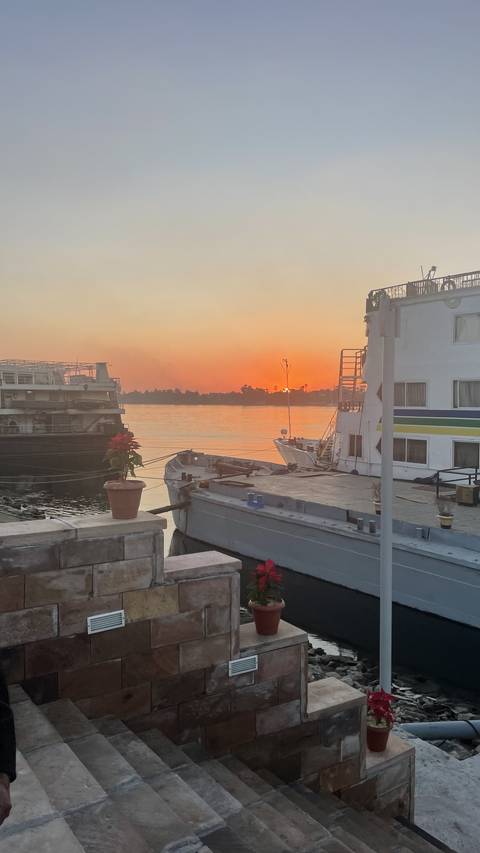 Sunset view over a river with boats docked.