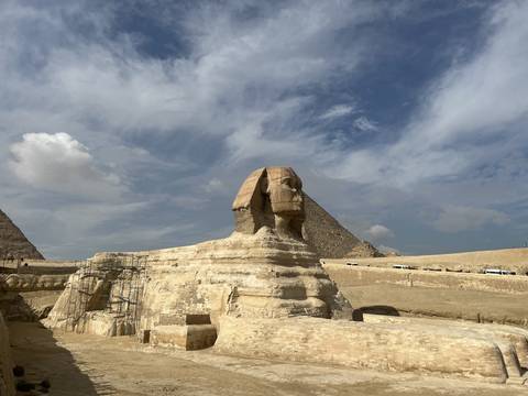 The Sphinx in Giza, Egypt with pyramids in the background.