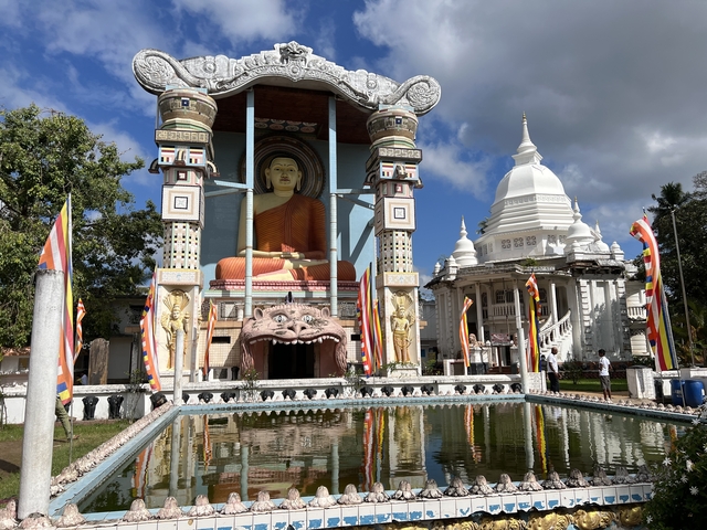 Temple complex with large Buddha statue and traditional architecture.