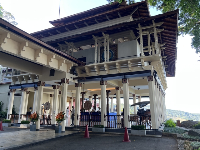 Elegant building with white columns and wooden roof.