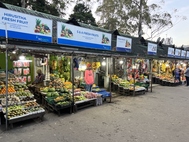 Colorful fruit market with stalls and fresh produce displayed.