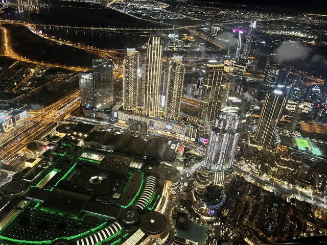 Aerial view of illuminated Dubai skyline at night.