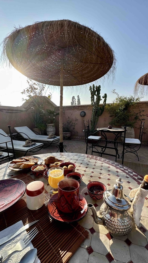 Rooftop terrace with breakfast setting and loungers.