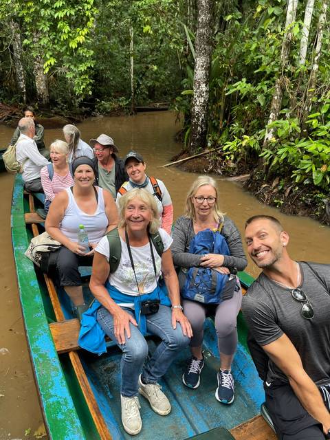 Group in a canoe on the water surrounded by vegetation.