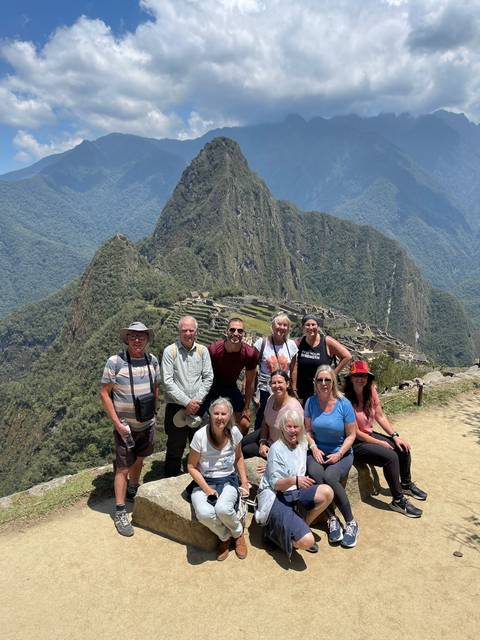 Group of people posing with a mountain backdrop.