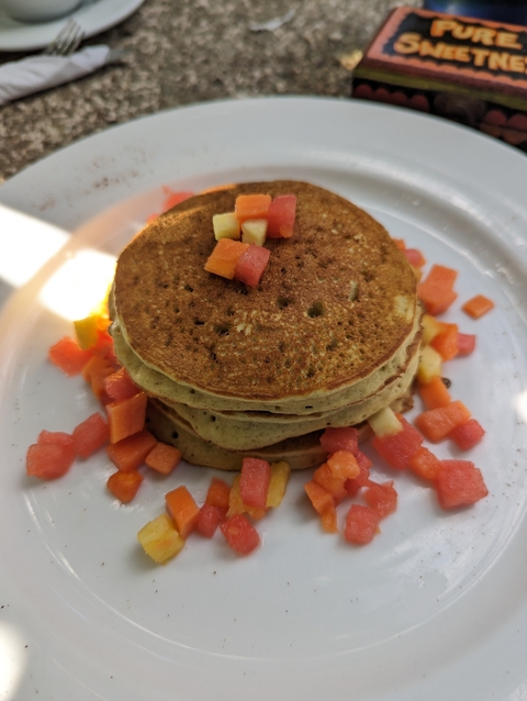 Stack of pancakes with fruit garnish.