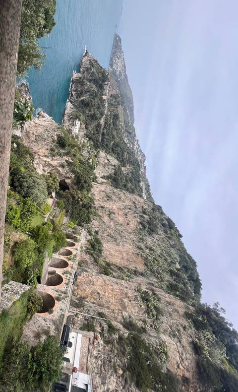 A scenic coastal view with cliffs and a roadway.