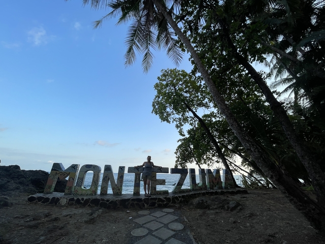 Montezuma sign with palm trees and a person.