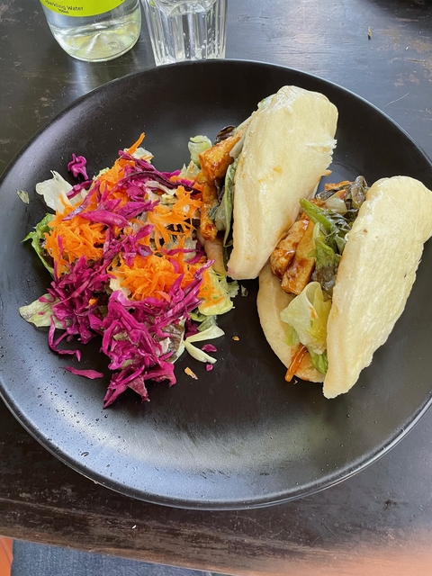 Plate of colorful salad and bao buns with vegetables.