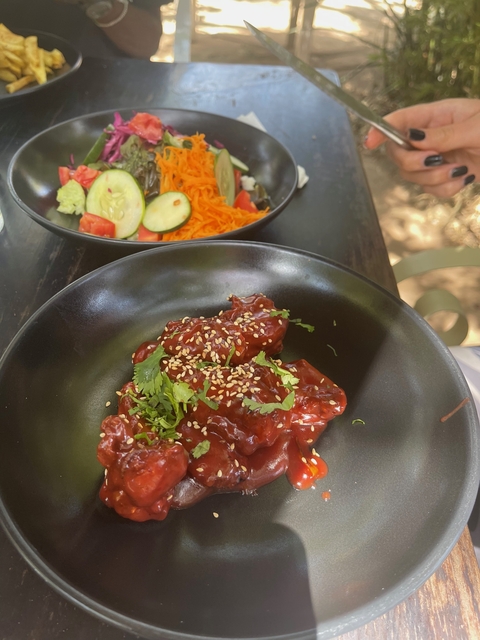 A dish with a salad and a cooked meal.