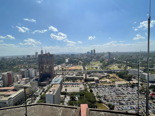 Panoramic view of a city with skyscrapers and greenery.