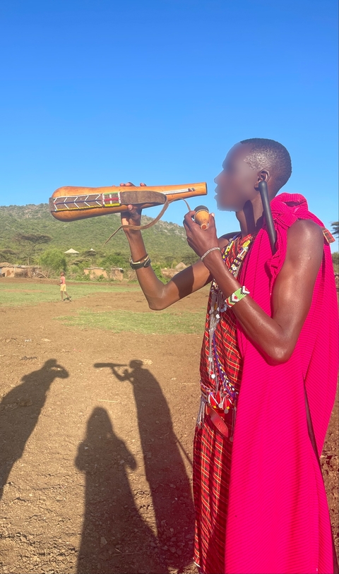 Person with traditional attire and musical instrument.