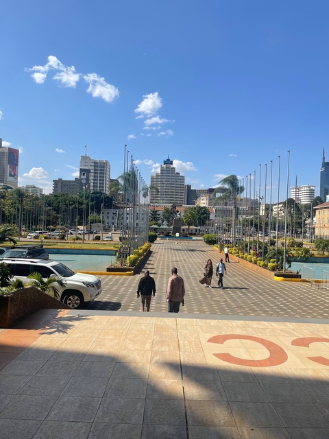 People walking on a paved area with skyscrapers in the background.