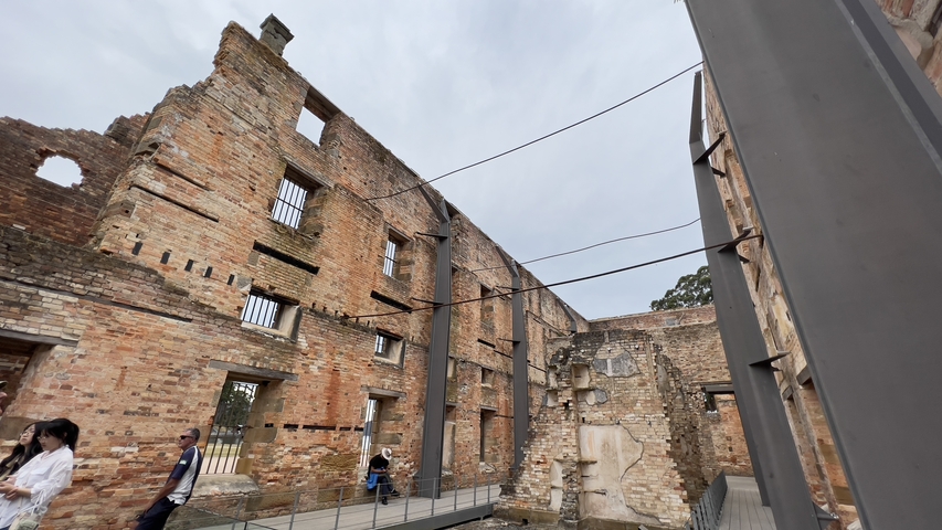 Historic building ruins with people walking.