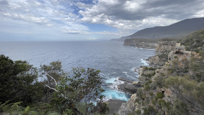 Coastal cliffs with waves crashing against them.