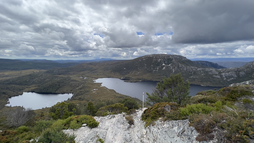 Panoramic mountain lake view under cloudy sky.